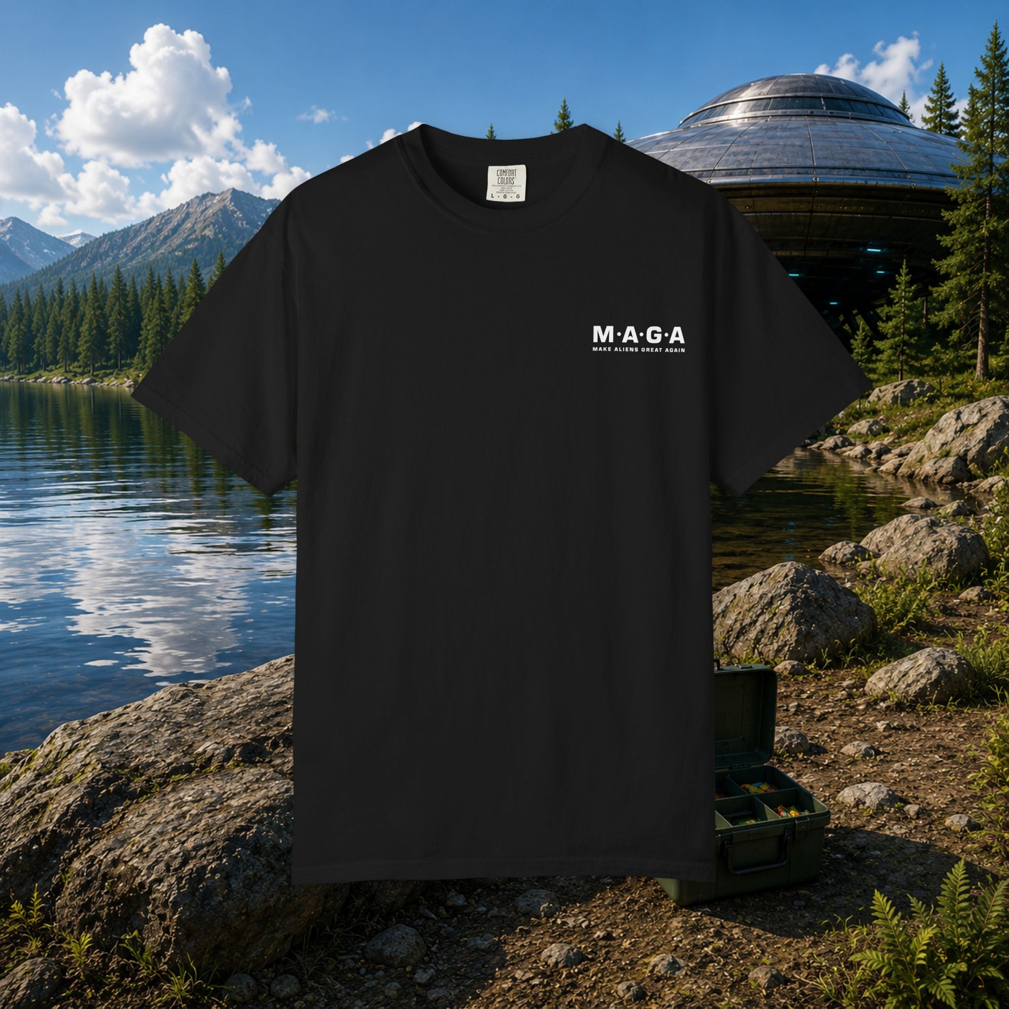 The MAGA Shirt in Black — front view showing white M·A·G·A left chest hit with Make Aliens Great Again text, mountain lake and UFO setting