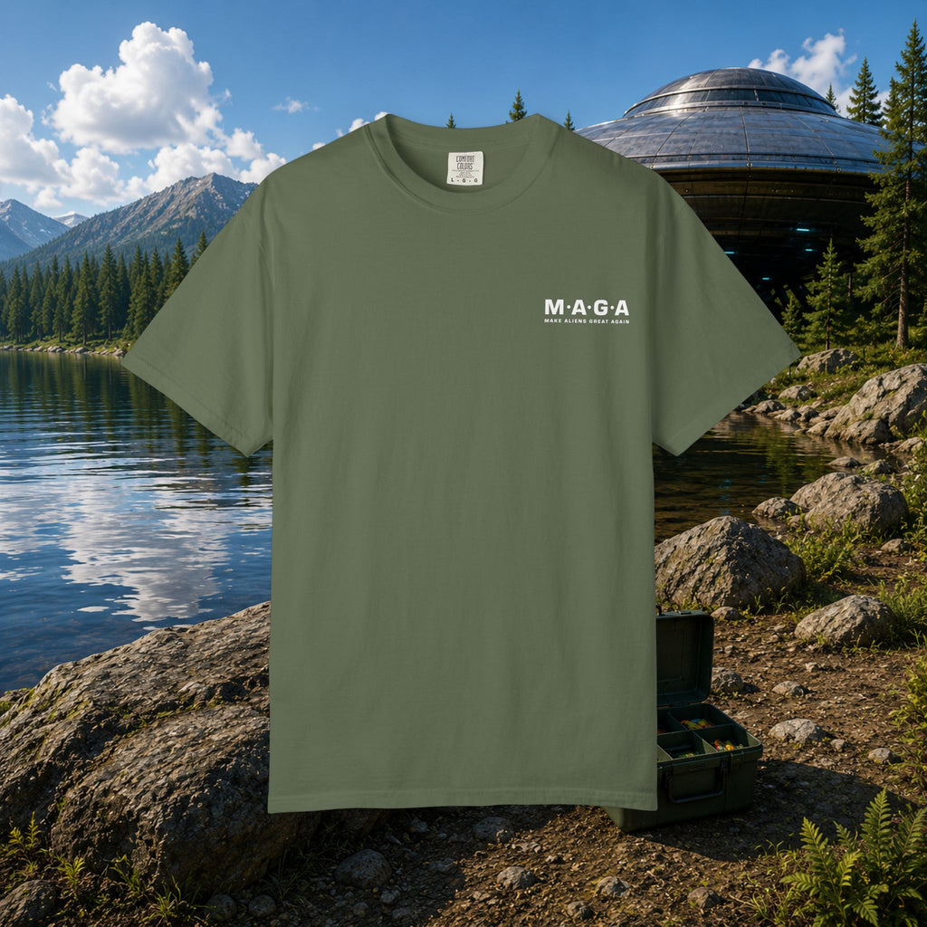 The MAGA Shirt in Sage — front view showing small M·A·G·A left chest hit with Make Aliens Great Again text, mountain lake and UFO backdrop