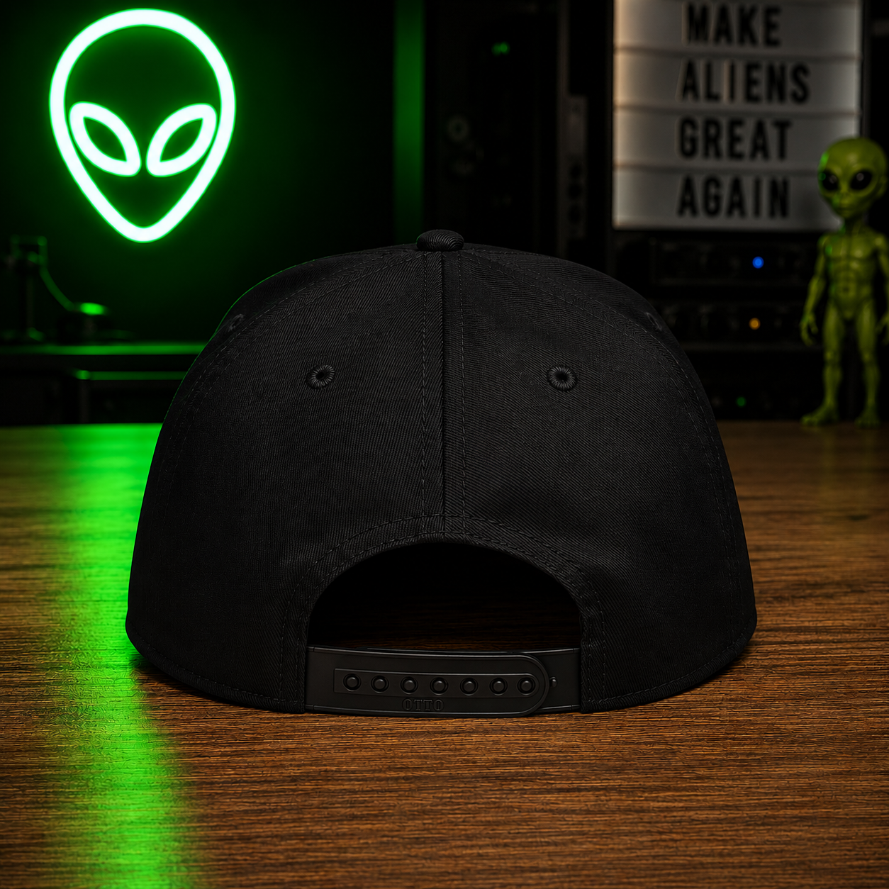 The Official $MAGA Hat — back view showing flat snap closure on black structured cap, MAKE ALIENS GREAT AGAIN lightbox visible in background
